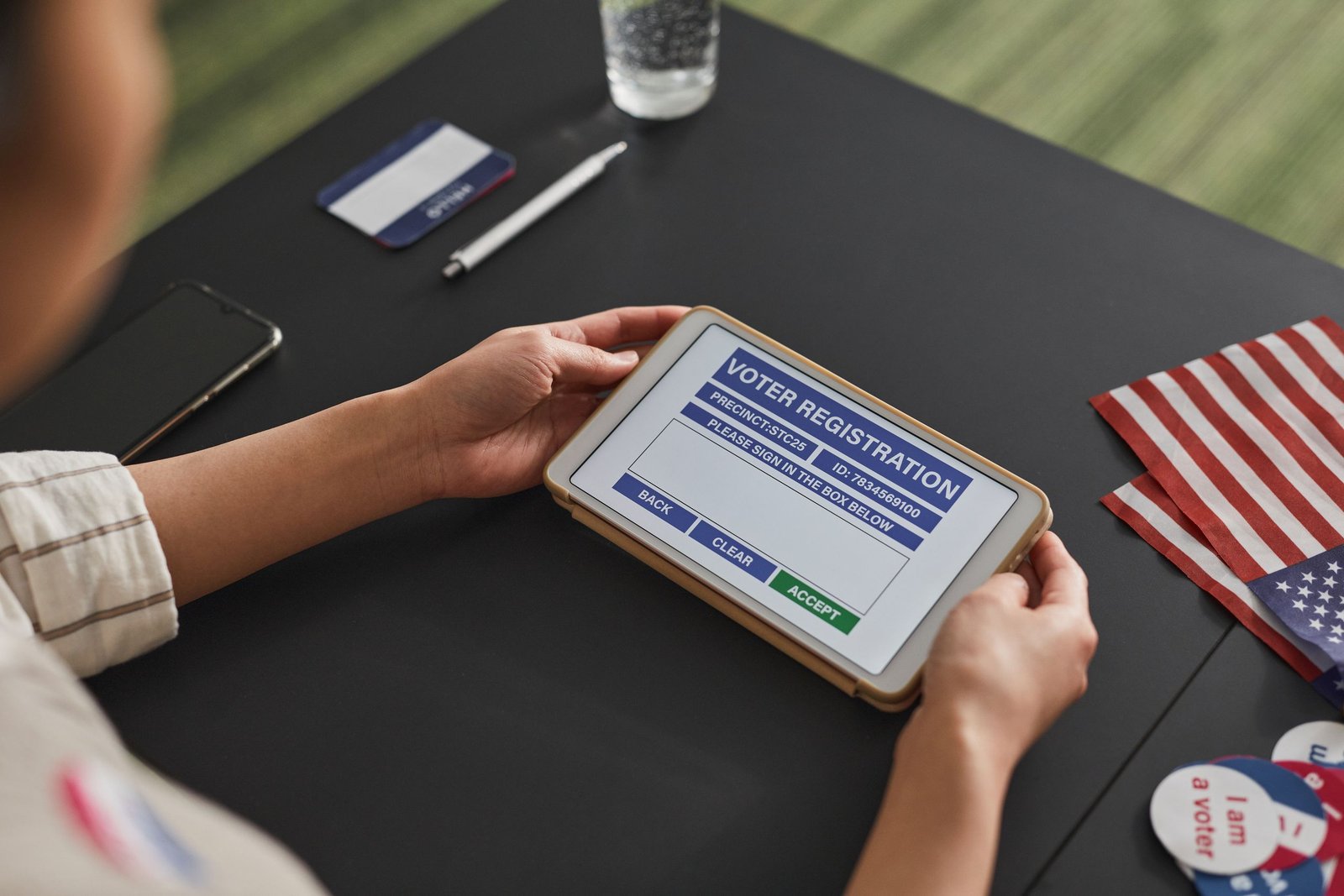 A person using a tablet for voter registration